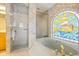 Bathroom with a soaking tub next to stained glass and a separate shower stall with white tile at 888 Royal Birkdale Dr, Tarpon Springs, FL 34688
