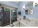 Blue bathroom featuring a tiled shower, white fixtures, and wainscoting at 888 Royal Birkdale Dr, Tarpon Springs, FL 34688