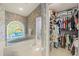 The bathroom features a stained glass window, soaking tub, and a walk-in closet with ample storage at 888 Royal Birkdale Dr, Tarpon Springs, FL 34688