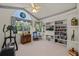 Sunlit bedroom with large windows, a bookshelf, and exercise equipment at 888 Royal Birkdale Dr, Tarpon Springs, FL 34688