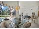 Light-filled dining area with a glass table, stylish chairs, and views of the pool and living space at 888 Royal Birkdale Dr, Tarpon Springs, FL 34688