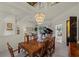 Formal dining room with mirrored ceiling, chandelier, and view into the living spaces at 888 Royal Birkdale Dr, Tarpon Springs, FL 34688