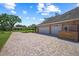 Close up of the three car garage and lovely brick driveway at 888 Royal Birkdale Dr, Tarpon Springs, FL 34688