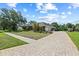 Close up of the three car garage and lovely brick driveway at 888 Royal Birkdale Dr, Tarpon Springs, FL 34688