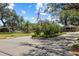 Community entrance with a guard house, lush landscaping, and an American flag creating a welcoming atmosphere at 888 Royal Birkdale Dr, Tarpon Springs, FL 34688
