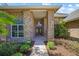 Charming brick home featuring a walkway to the front door with sidelight windows and landscaping at 888 Royal Birkdale Dr, Tarpon Springs, FL 34688
