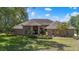 Charming brick home featuring arched windows, lush landscaping, and a well-maintained lawn on a sunny day at 888 Royal Birkdale Dr, Tarpon Springs, FL 34688