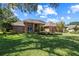 Well-manicured lawn and landscaping highlight the front of this brick home at 888 Royal Birkdale Dr, Tarpon Springs, FL 34688