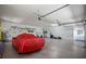 Well-lit garage with ample storage space and a vehicle covered with a red tarp at 888 Royal Birkdale Dr, Tarpon Springs, FL 34688