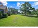 View of a manicured lawn with mature trees overlooking a golf course at 888 Royal Birkdale Dr, Tarpon Springs, FL 34688