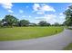 Picturesque golf course view with lush green fairways, mature trees, and a smooth cart path at 888 Royal Birkdale Dr, Tarpon Springs, FL 34688
