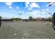Well-maintained tennis courts, surrounded by mature trees and landscaping with nearby shelter at 888 Royal Birkdale Dr, Tarpon Springs, FL 34688