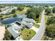 Aerial view of a home featuring a pond, pool and manicured lawn with quiet neighborhood at 9010 Penelope Dr, Weeki Wachee, FL 34613