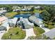 Aerial view of a home with a pond, pool and a well-manicured lawn in a quiet neighborhood at 9010 Penelope Dr, Weeki Wachee, FL 34613