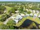 Beautiful aerial view showcases homes with screened pools near a golf course and a tranquil lake at 9010 Penelope Dr, Weeki Wachee, FL 34613