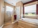 Bright bathroom features a glass shower, soaking tub and neutral tones at 9010 Penelope Dr, Weeki Wachee, FL 34613