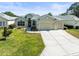 Charming one-story home featuring a well-manicured lawn, a two-car garage, and a welcoming facade at 9010 Penelope Dr, Weeki Wachee, FL 34613