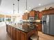 Large kitchen island with dark countertops, stainless steel appliances, and custom cabinets with wood finish at 9010 Penelope Dr, Weeki Wachee, FL 34613