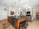 Open concept kitchen with island, stainless steel appliances, wood cabinets, and view to the living room at 9010 Penelope Dr, Weeki Wachee, FL 34613