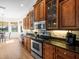 Kitchen with stainless steel appliances, granite counters, and wooden cabinets with a small desk area at 9010 Penelope Dr, Weeki Wachee, FL 34613