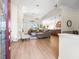 Open concept living room with modern flooring, a ceiling fan, and a view into the kitchen at 9010 Penelope Dr, Weeki Wachee, FL 34613