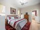 Comfortable main bedroom with ceiling fan, dresser, and ensuite bathroom entrance at 9010 Penelope Dr, Weeki Wachee, FL 34613