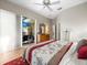 Bright main bedroom with ceiling fan, dresser, and lanai access through sliding door at 9010 Penelope Dr, Weeki Wachee, FL 34613