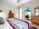Main bedroom with a ceiling fan, dresser, and sliding glass door to the lanai at 9010 Penelope Dr, Weeki Wachee, FL 34613