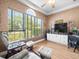 Spacious home office featuring large window, ceiling fan, and desk area at 9010 Penelope Dr, Weeki Wachee, FL 34613
