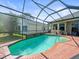 Screened-in pool with brick trim and tile water feature offers a relaxing outdoor space at 9010 Penelope Dr, Weeki Wachee, FL 34613