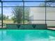 Screened-in pool with fountains overlooking a grassy area at 9010 Penelope Dr, Weeki Wachee, FL 34613