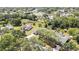 Expansive aerial view of a charming home with a screened-in pool and lush green landscaping at 9088 Gallup Cir, Spring Hill, FL 34608