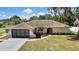 Aerial view of a home with spacious driveway and well-manicured lawn, set in a serene neighborhood at 9088 Gallup Cir, Spring Hill, FL 34608