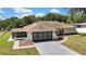 Aerial view of home with a screen patio and a two car garage, surrounded by a green lawn at 9088 Gallup Cir, Spring Hill, FL 34608