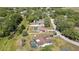Aerial view of a home with an enclosed swimming pool and driveway, surrounded by mature trees at 9088 Gallup Cir, Spring Hill, FL 34608