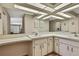 Bright bathroom with a spacious vanity, dual sinks, mirrored walls and modern lighting at 9088 Gallup Cir, Spring Hill, FL 34608