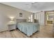 Serene bedroom with neutral colors, wood flooring, ceiling fan, and well-organized closet space at 9088 Gallup Cir, Spring Hill, FL 34608