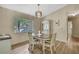 Cozy dining room featuring hardwood floors, a stylish chandelier, and a sunlit window with lush outdoor views at 9088 Gallup Cir, Spring Hill, FL 34608