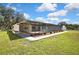 Lush backyard view features a screened in pool and patio and manicured lawn with attractive landscaping at 9088 Gallup Cir, Spring Hill, FL 34608