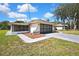 Well-maintained house exterior with a screen patio and a two car garage on a grassy lawn at 9088 Gallup Cir, Spring Hill, FL 34608