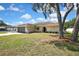Charming home exterior with manicured lawn and mature trees, enhancing curb appeal at 9088 Gallup Cir, Spring Hill, FL 34608