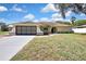 Charming single-story home with a neutral color scheme, well-maintained lawn, and an attached two-car garage at 9088 Gallup Cir, Spring Hill, FL 34608