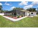 Exterior shot of a well maintained home with manicured lawn, landscaping and screened in pool at 9088 Gallup Cir, Spring Hill, FL 34608