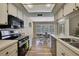 Bright kitchen with white cabinets, a black oven, and an open layout connecting to the adjacent dining area at 9088 Gallup Cir, Spring Hill, FL 34608