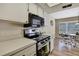 Well-lit kitchen features stainless steel appliances, oven, microwave, and white countertops at 9088 Gallup Cir, Spring Hill, FL 34608