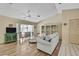 Living area with hardwood floors, a ceiling fan, an open floorplan, and a display shelving unit at 9088 Gallup Cir, Spring Hill, FL 34608