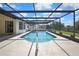 An inviting screened in swimming pool with an entrance ramp for easy access in a backyard at 9088 Gallup Cir, Spring Hill, FL 34608