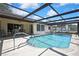Screened-in pool with clear water, access ladder, and lounge chairs, for relaxing and entertaining at 9088 Gallup Cir, Spring Hill, FL 34608