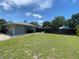 Large backyard featuring a manicured lawn, privacy fencing, landscaping and exterior shed at 9186 Patio Ct, Spring Hill, FL 34608