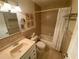 Cozy bathroom featuring a tub with shower, neutral tile, and a vanity with bright lighting at 9186 Patio Ct, Spring Hill, FL 34608